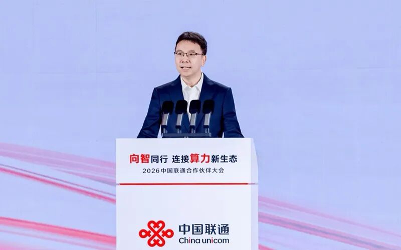 杨超斌在2026中国联通合作伙伴大会讲台发表主题演讲，非机房部署照片。